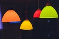 Hanging color lampshades on dark background. Composition of multi-colored chandeliers in interior design. Royalty Free Stock Photo