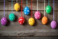 Hanging colorful eggs on wooden background