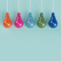 Hanging colorful pantone pastel light bulbs different idea on light blue background