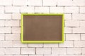 Hanging colorful photo frame on brick wall in loft concept style. Blank vivid border for your design or show at gallery room