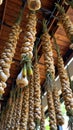 Hanging garlic braids curing on ceiling with wooden beams in sunlit interior Royalty Free Stock Photo