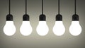 Hanging glowing tungsten light bulbs on gray