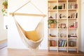 hanging hammock chair with a small bookshelf nearby