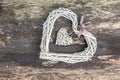 Hanging heart and wooden background in country style.