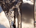 An icicle illuminated by sunlight against the sky