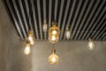 Hanging light bulbs over grey dark strip ceiling Royalty Free Stock Photo