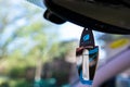 Hanging liquid Paloma Blue Lagoon air freshener on car interior.