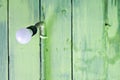 Hanging modern light bulb with green wooden planks Royalty Free Stock Photo