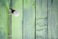 Hanging modern light bulb with green wooden planks background Royalty Free Stock Photo