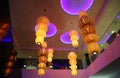 Hanging multi-tiered round yellow lamps on the background of the ceiling with lilac circles. Architecture