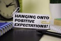 Hanging Onto Positive Expectation on the paper isolated on it desk. Business and inspiration concept