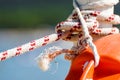 Hanging orange life belt with long rope at the beach, security and safety concept