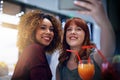 Hanging out at our favourite party place. two young friends taking a selfie while having drinks at a party. Royalty Free Stock Photo