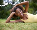 Hanging out in the park. Portrait of a happy young woman lying on the grass in a park. Royalty Free Stock Photo