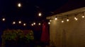 Hanging outdoor lights over patio in summer night Royalty Free Stock Photo