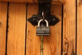 Hanging padlock on closed wooden plank gates Royalty Free Stock Photo