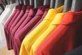 Hanging red, yellow, dark purple and white polo shirts
