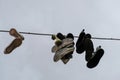 Hanging sneakers shoes over bright cloudy sky,urban city art symbol lifestyle Royalty Free Stock Photo