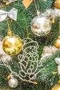 Hanging snowman decoration on the Christmas tree. Gold and silver baubles, multi-colored bows, animals, bells, lit garlands Royalty Free Stock Photo