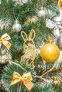 Hanging squirrel figure decoration on the Christmas tree. Gold and silver baubles, multi-colored bows, bells, lit garlands against Royalty Free Stock Photo