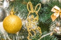 Hanging squirrel figure decoration on the Christmas tree. Gold and silver baubles, multi-colored bows, bells, lit garlands against Royalty Free Stock Photo