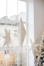 Hanging star lantern lights during holiday winter season. Decoration White Christmas stars in window. Advent time. A lamp in shape Royalty Free Stock Photo