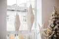 Hanging star lantern lights during holiday winter season. Decoration White Christmas stars in window. Advent time. A lamp in shape