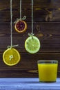 Summer drink. Hanging on threads slices of lemon, orange and lime. Summer fresh, glass of orange juice Royalty Free Stock Photo