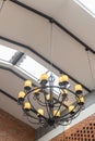 Hanging vintage black Chandelier ceiling with yellow lamp and brick wall interior Royalty Free Stock Photo