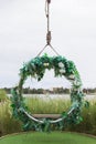 Hanging vintage wooden swing decorated with flowers and leaf. The design for decor place at outdoor