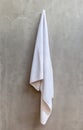 Hanging white towel draped on exposed concrete wall in the bathroom Royalty Free Stock Photo