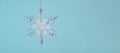 Hanging Winter snowflake close-up on a blue monochrome background. Selective focus, copy space, banner Royalty Free Stock Photo