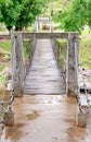 Hanging wooden bridge over the stream Royalty Free Stock Photo