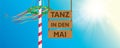 hanging wooden sign -tanz in den mai- maypole with colorful ribbons