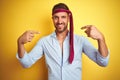 Hangover business man drunk and crazy for hangover wearing tie on head looking confident with smile on face, pointing oneself with