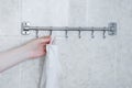 Hangs a white towel on a metal hanger in bathroom Royalty Free Stock Photo