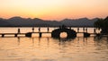 Hangzhou, China - November 9 2019: Beautiful sunset at the West Lake, people walking on the bridges by the lake