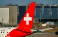 Rear wing of a Helvetc Airwys aircraft with a white crucifix on red background