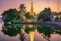Hanoi buddhist pagoda on West Lake, colorful sunset, illuminated temple, water reflection. Chua Tran Quoc on Ho Tay at Hanoi,