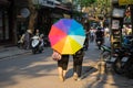 Hanoi, Vietnam - Apr 24, 2016: Colorful umbrella of two girls in Hang Vai street. With typical weather of tropical monsoon type, H