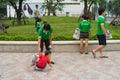 Hanoi, Vietnam - Apr 19, 2015: Family volunteers picking up litter in the park at Times City, a luxury and high class combination