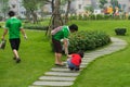 Hanoi, Vietnam - Apr 19, 2015: Family volunteers picking up litter in the park at Times City, a luxury and high class combination