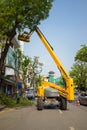 Hanoi, Vietnam - Apr 24, 2016: Mechanical platform to make tree pruning on Dinh Tien Hoang street, center of Hanoi capital