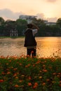 Photographer capturing Hoan Kiem Lake at sunset