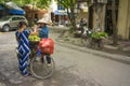 Hanoi, Vietnam - April 13, 2014: Unidentified food vendor sells fruits carried by bike to a woman on Hanoi street, Vietnam Royalty Free Stock Photo