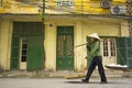 Hanoi, Vietnam - April 13, 2014: Unidentified vendor goes home with the empty baskets over old house on Hanoi str, Vietnam