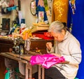 HANOI, VIETNAM - DECEMBER 16, 2016: Seamstress sews dresses on the local market. Close-up.