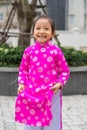 Hanoi, Vietnam - Feb 7, 2015: Little girl with Vietnamese traditional long dress Ao Dai playing at Vietnamese lunar new year festi