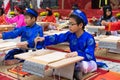 Hanoi, Vietnam - Feb 7, 2015: School children in traditional dress Ao Dai learning with calligraphy at Vietnamese lunar New Year c