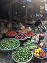 Hanoi, Vietnam, January 30, 2020 - View on a seller in the middle of a large assortment of row loose vegetables and fruits for